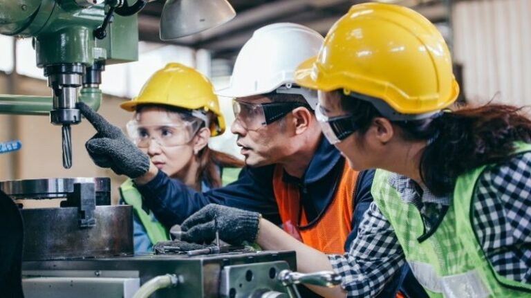 3 people on a construction jobsite collaborating around 1 task