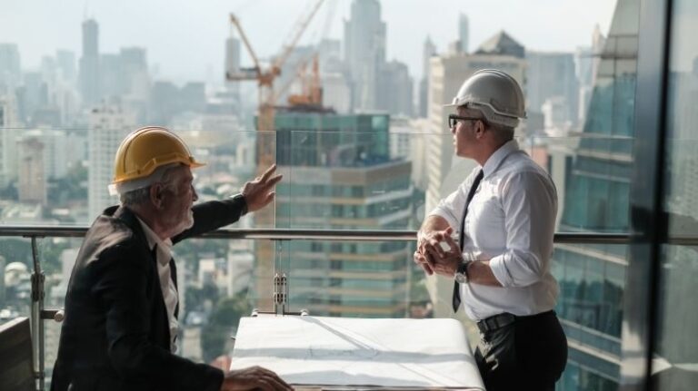 construction engineering management meeting between manager and worker looking out over skyline with building under construction