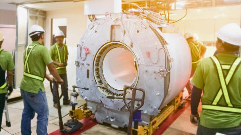 Contractors installing an MRI scanner on a hospital construction project