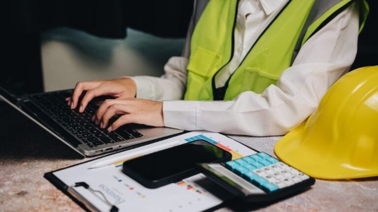 Worker using construction estimate template on a laptop