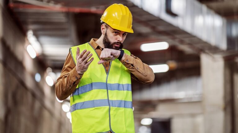 Construction pro on a jobsite talking into a wearable device (smartwatch)