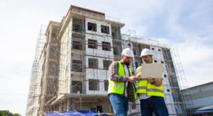 Contractors on a jobsite looking at a laptop