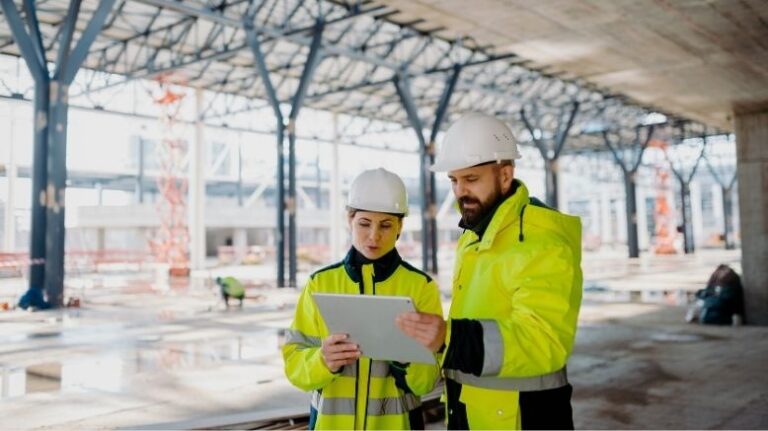 Two workers reviewing data on a tablet