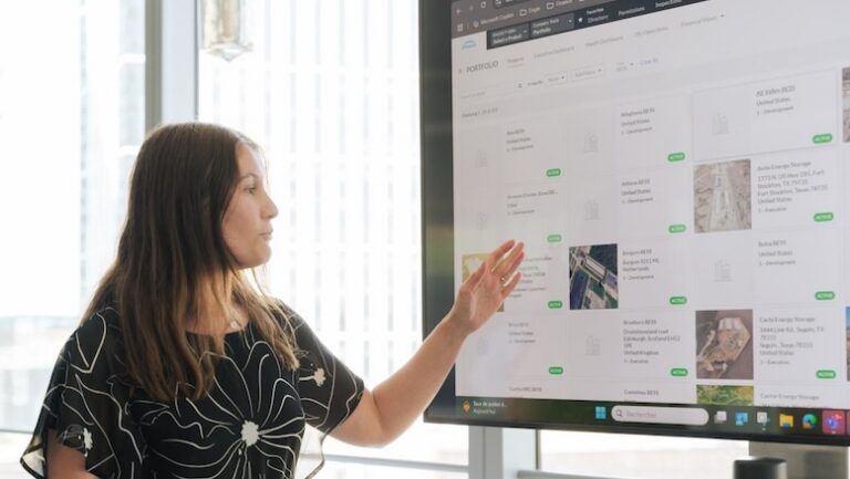 Construction project owner reviewing portfolio info on a conference room screen
